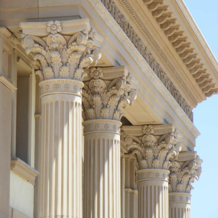Les 4 piliers du contrat de construction en Algérie – symbole architectural Quatre piliers romains représentant les quatre bases essentielles d’un contrat de construction réussi en Algérie selon un architecte algérien